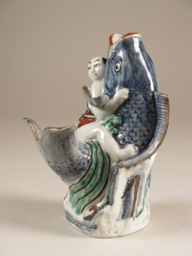 Vaas in de vorm van een opspringende karper waarop een zittende man, arita