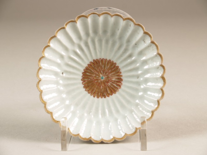 Schotel, rozetvormig geschulpt staand op een opgelegde tak in hoog reliëf met decor van bloem, famille rose